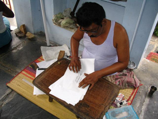 Designs are hand drawn and then pasted onto the wood for carving the blocks and printing